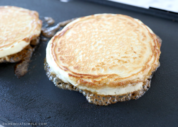 golden pancakes on a black griddle