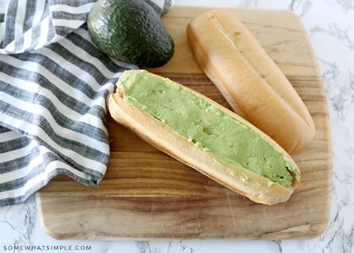 hot dog topped with avocado