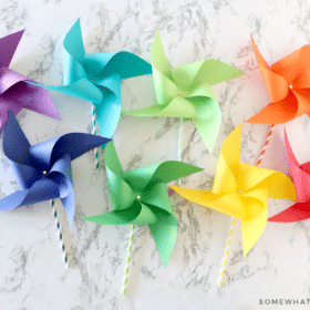 8 paper pinwheels in different colors of the rainbow laying on the counter