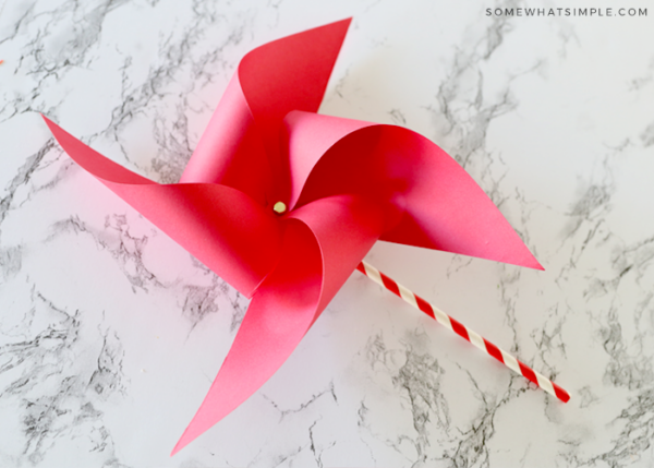 finished paper pinwheel with red paper on the counter