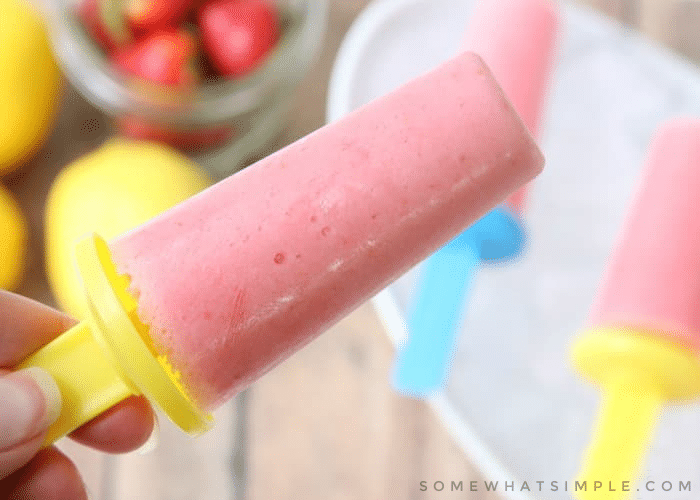 holding strawberry lemonade yogurt pops