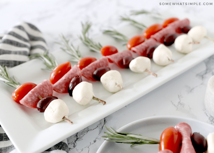 caprese skewers on a white serving platter