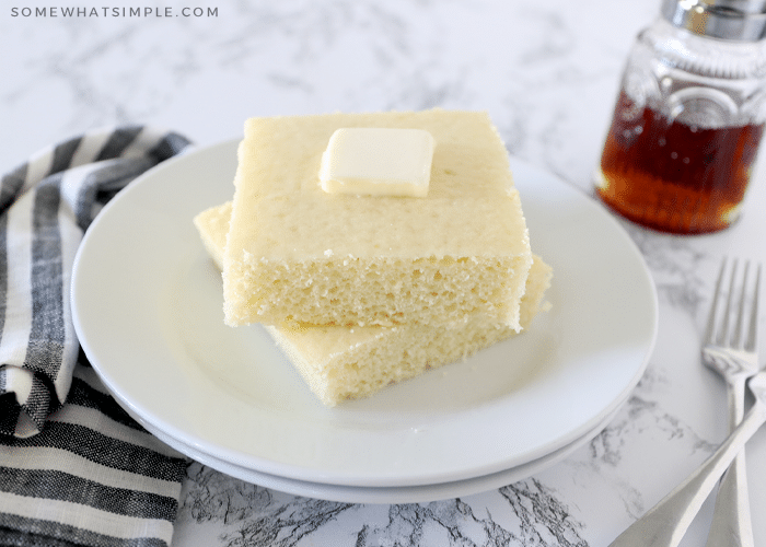 baked pancakes stacked on a plate with a pat of butter on top