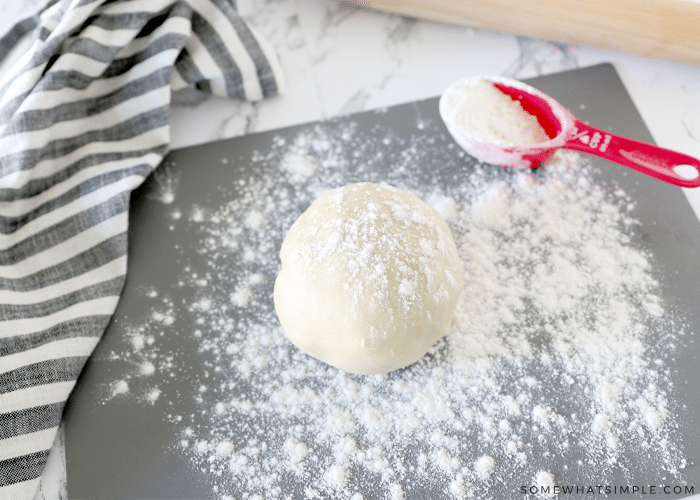 roll of cookie dough on a floured work surface