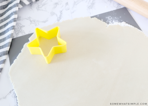 yellow star cookie cutter on sugar cookie dough