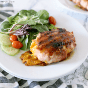 grilled chicken on a plate with a green salad