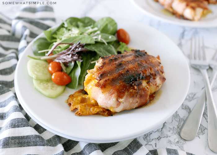 grilled chicken on a plate with a green salad