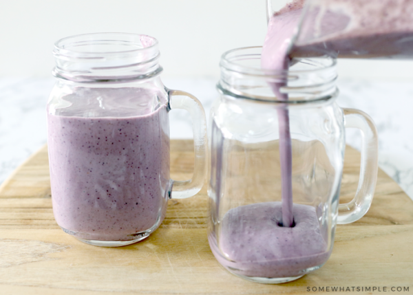 pouring a smoothie into a glass cup