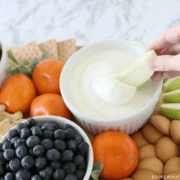 dipping an apple into marshmallow fruit dip