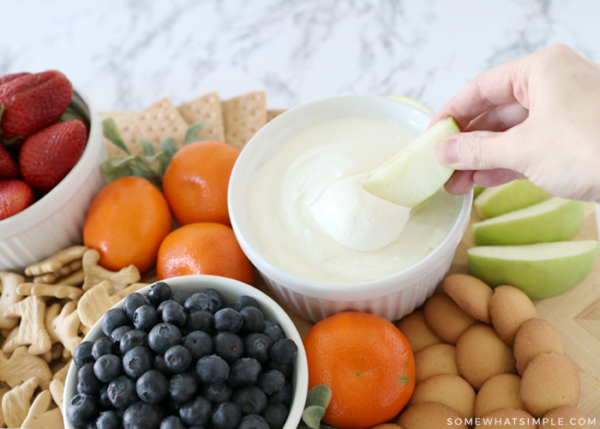 dipping an apple into marshmallow fruit dip