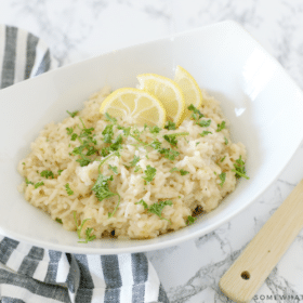 parmesan risotto with lemon slices in a white bowl
