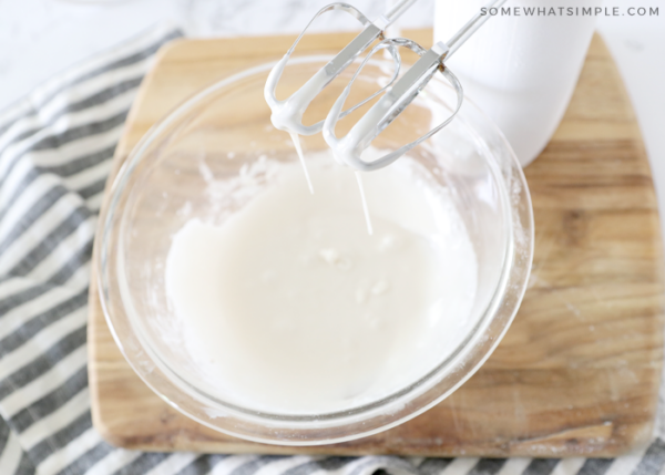 mixing frosting in a clear glass bowl