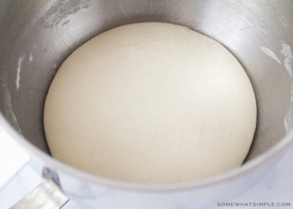 risen dough in a mixing bowl
