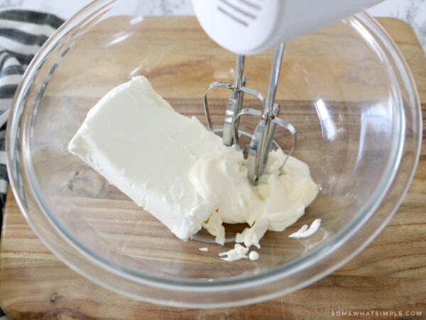 mixing cream cheese and mayo in a glass bowl