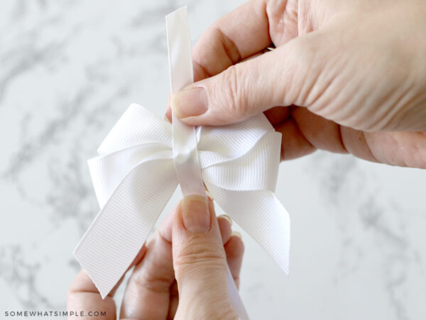 adding a ribbon to the center of a hair bow