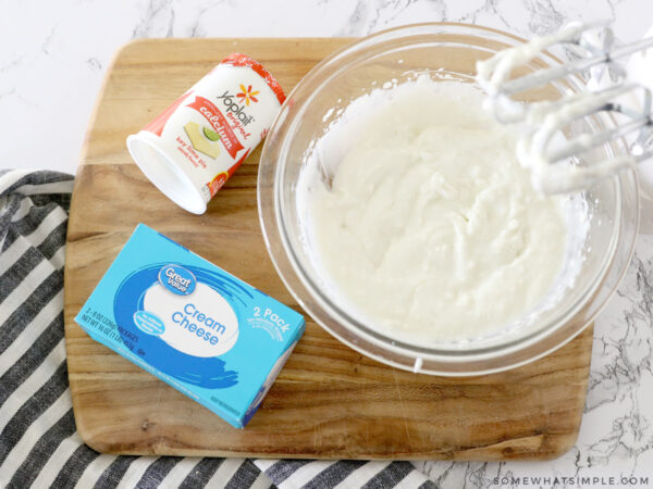 mixing yogurt, cream cheese and sugar in a glass bowl