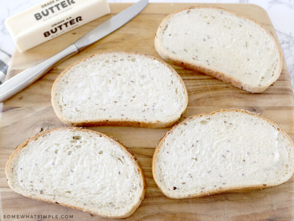 buttering each slice of bread for a sandwich