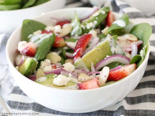 drizzle of poppyseed dressing on top of a strawberry salad