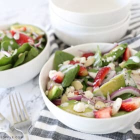 white bowl with strawberry spinach salad