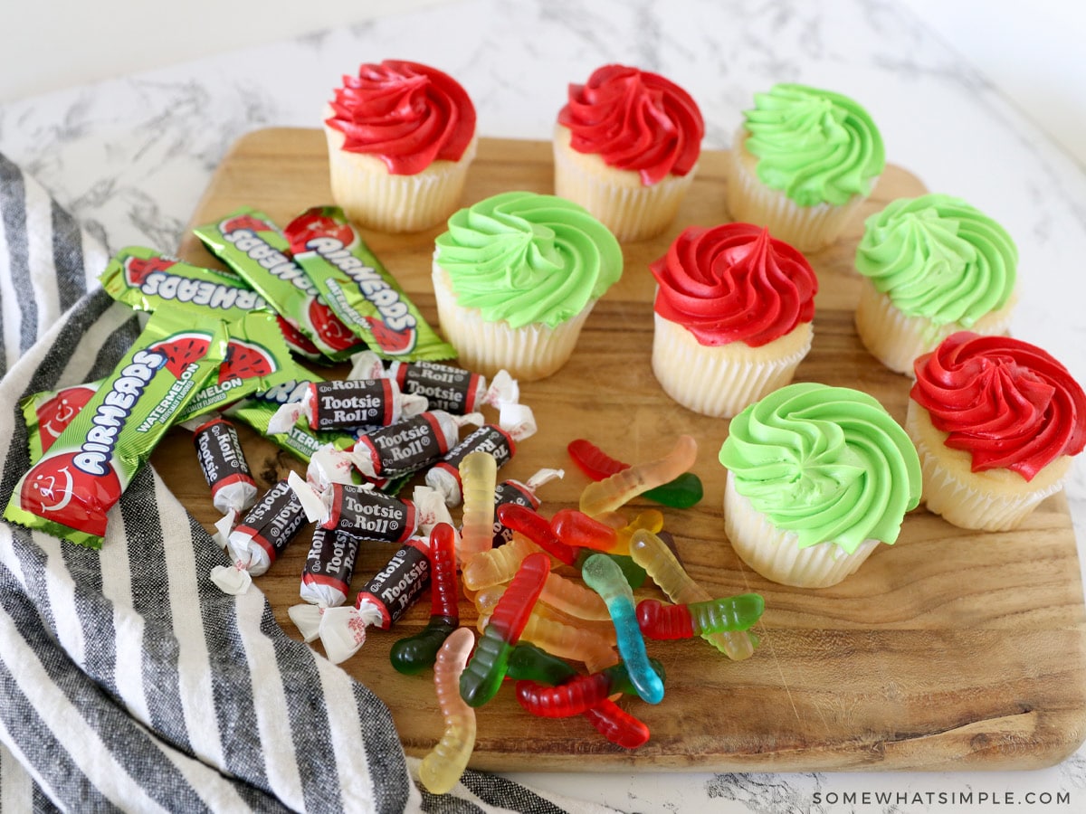 cupcakes and decorations on a cutting board