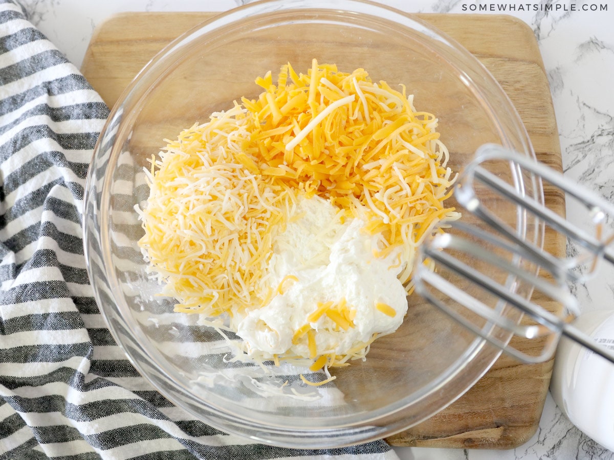 adding different cheeses to a bowl