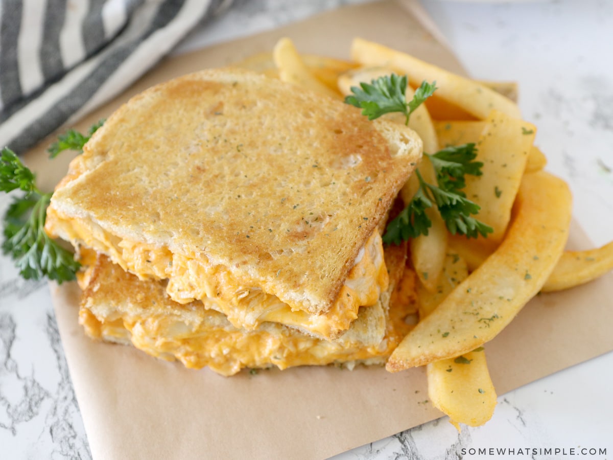 close up of a buffalo chicken grilled cheese sandwich with steak fries