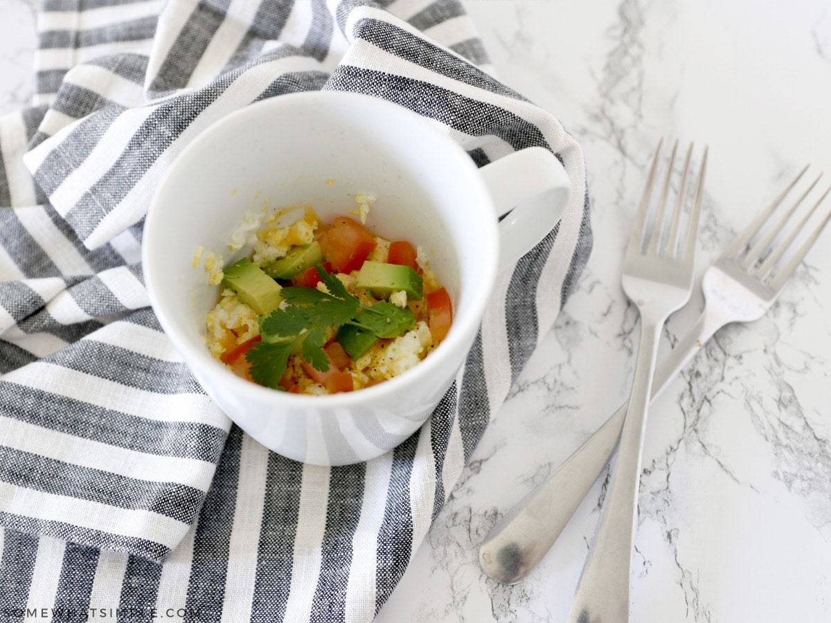 eggs in a mug with omelet toppings