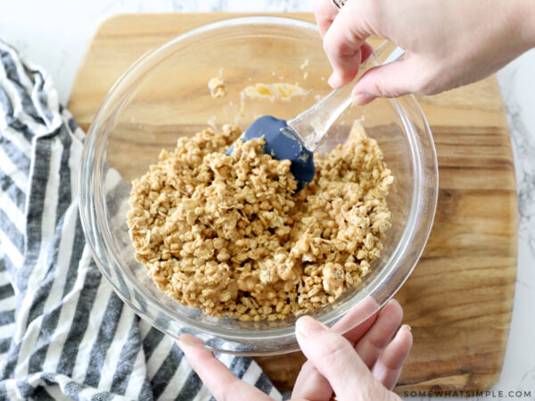 peanut butter, honey, and granola being mixed in a bowl