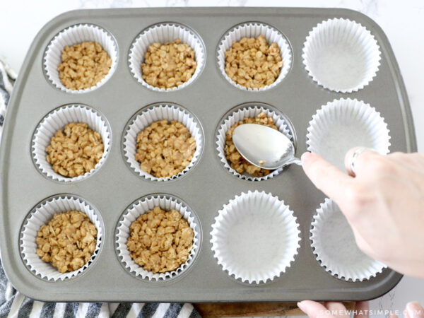 pressing granola into muffin tins