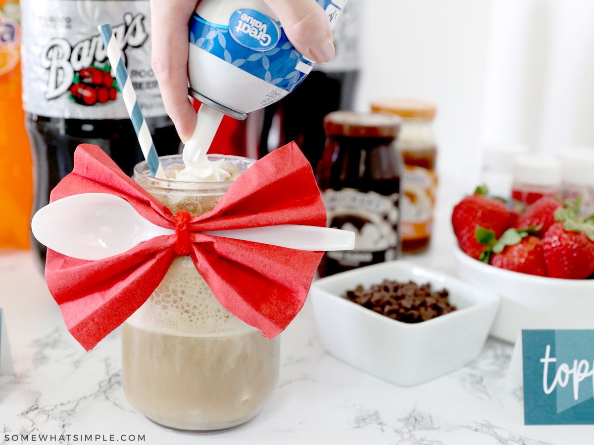 adding whipped cream to a root beer float