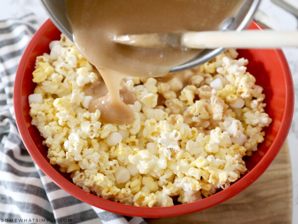 pouring caramel sauce over popcorn