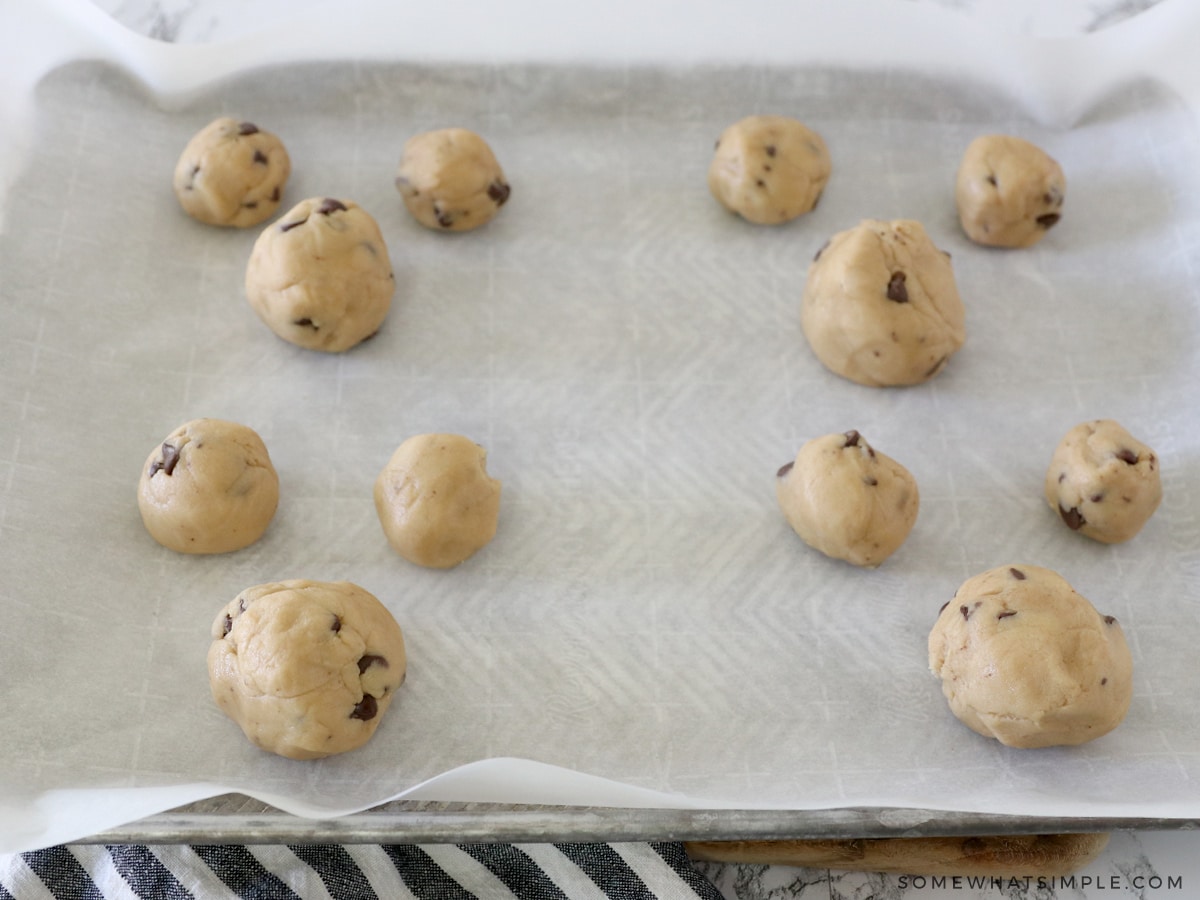 balls of chocolate chip cookie dough on a baking sheet