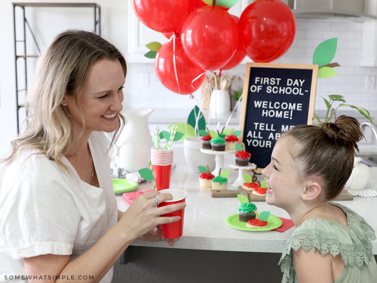 mom and daughter laughing at the counter with back to school treats