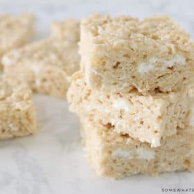 stack of brown butter rice krispy treats with more in the back ground