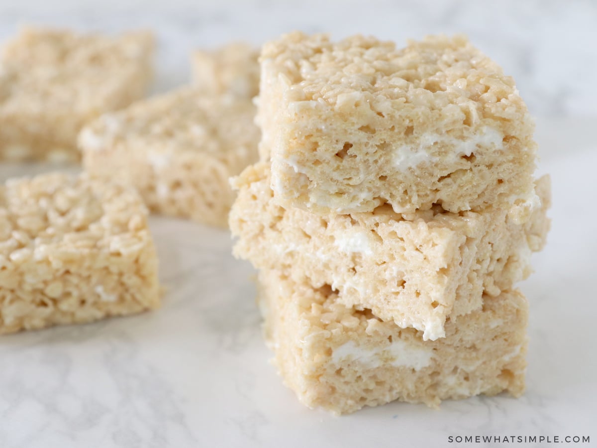 stack of brown butter rice krispy treats with more in the back ground