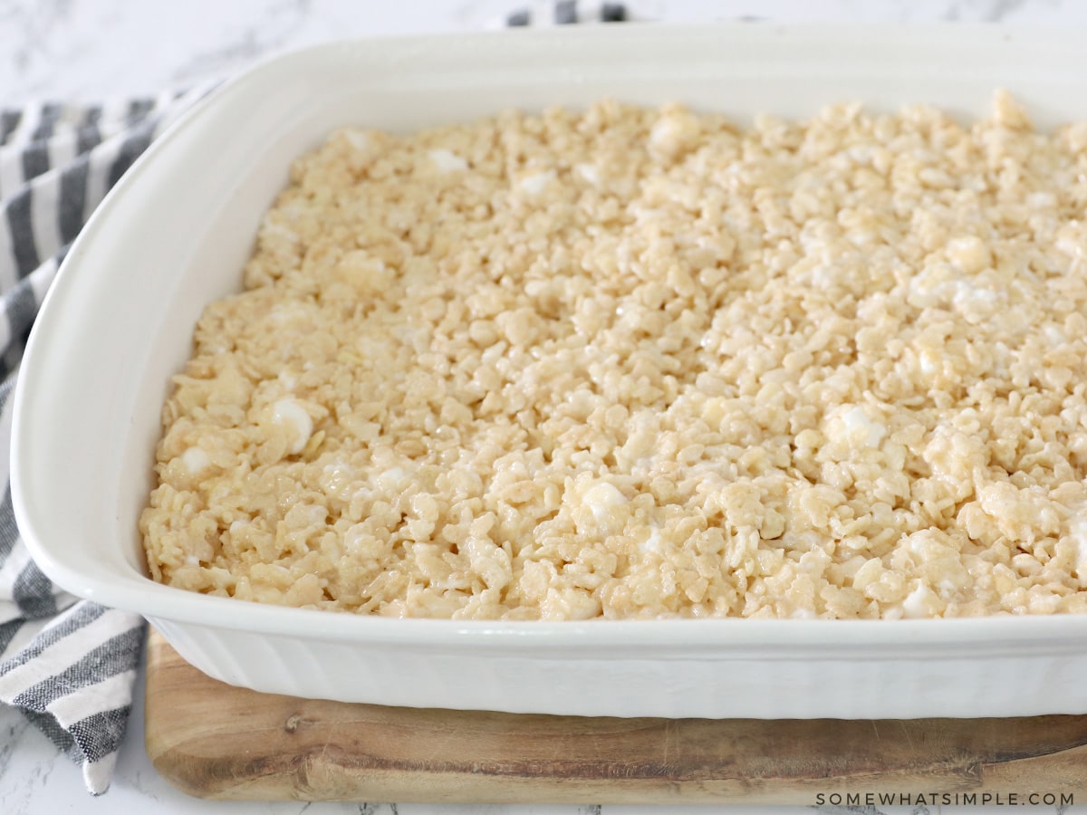 placing rice krispie treats into a casserole pan