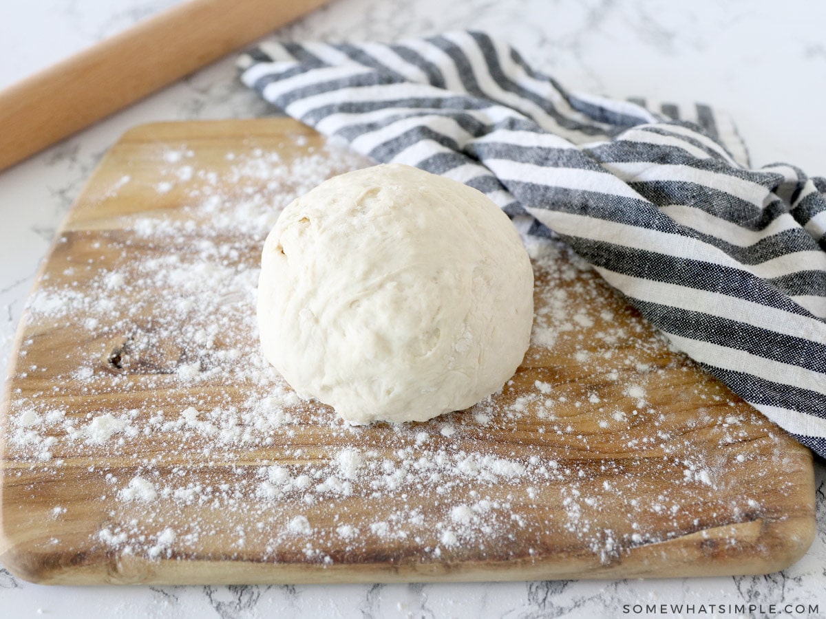 easy pizza dough recipe in a ball on a cutting board