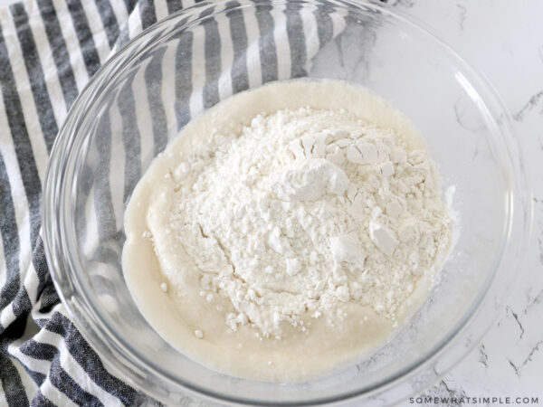adding flour to yeast and water