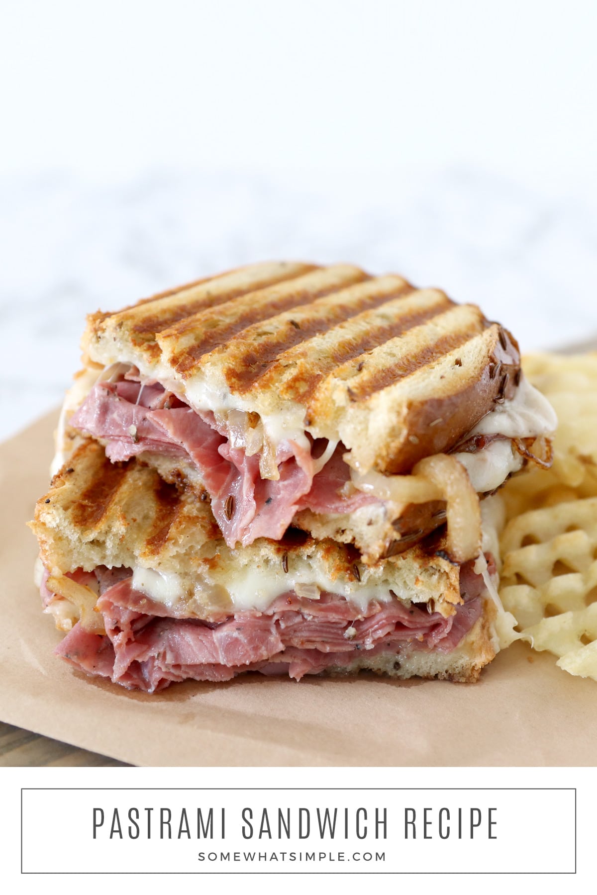 This pastrami sandwich recipe is perfect for those times when you need a quick and easy dinner idea. It's loaded with hot pastrami, grilled onions, mustard, cheese, and crispy waffle fries, this recipe is easy to make and unbelievably tasty! via @somewhatsimple