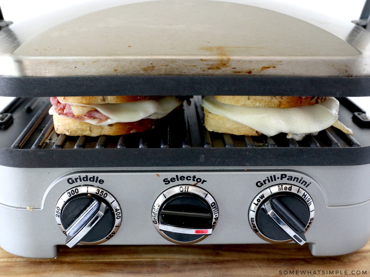 grilling two pastrami sandwiches on an indoor grill