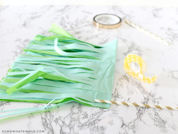 adding double sided tape to tissue paper pom poms