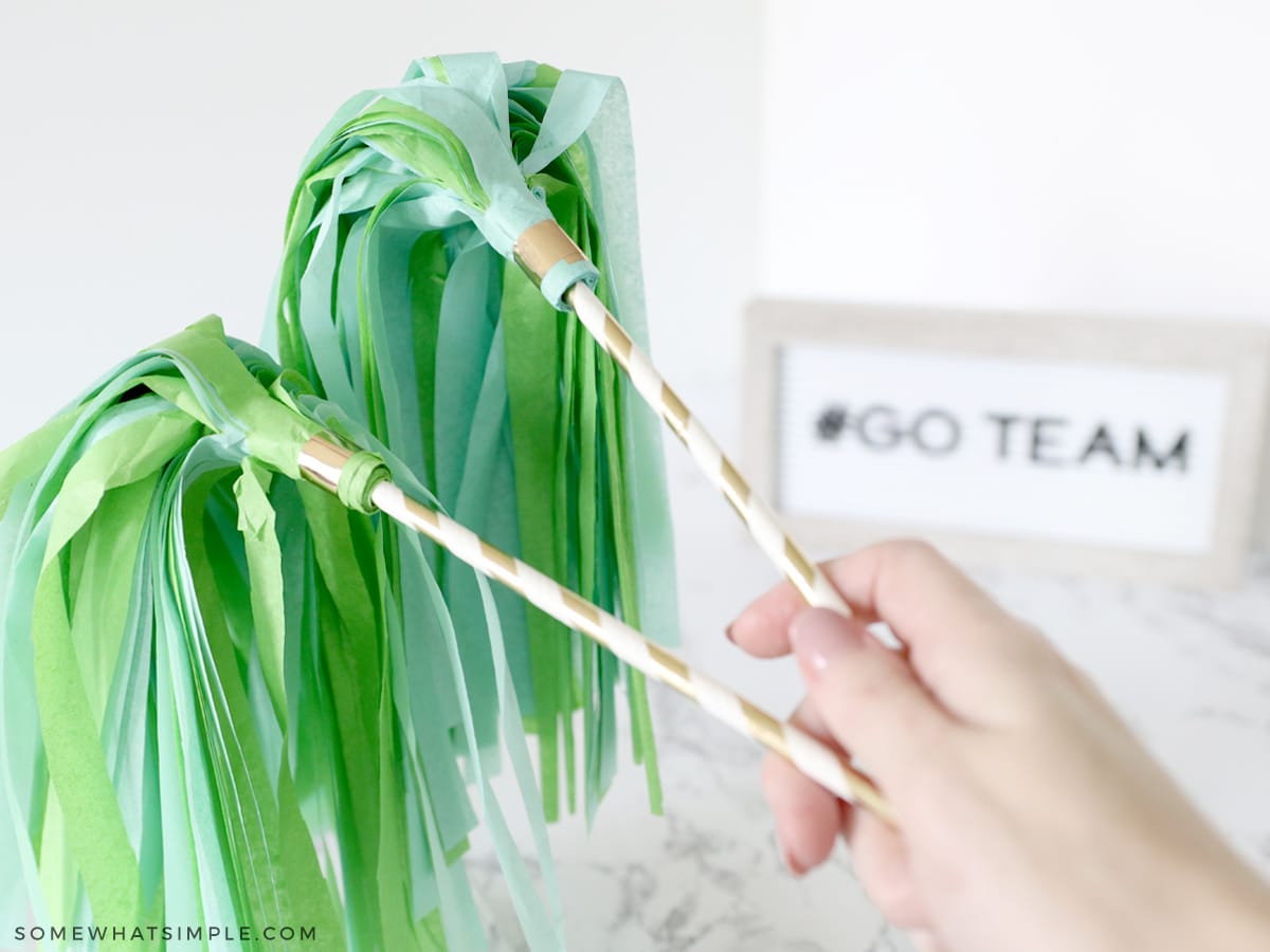 tissue paper pom poms attached to paper straws