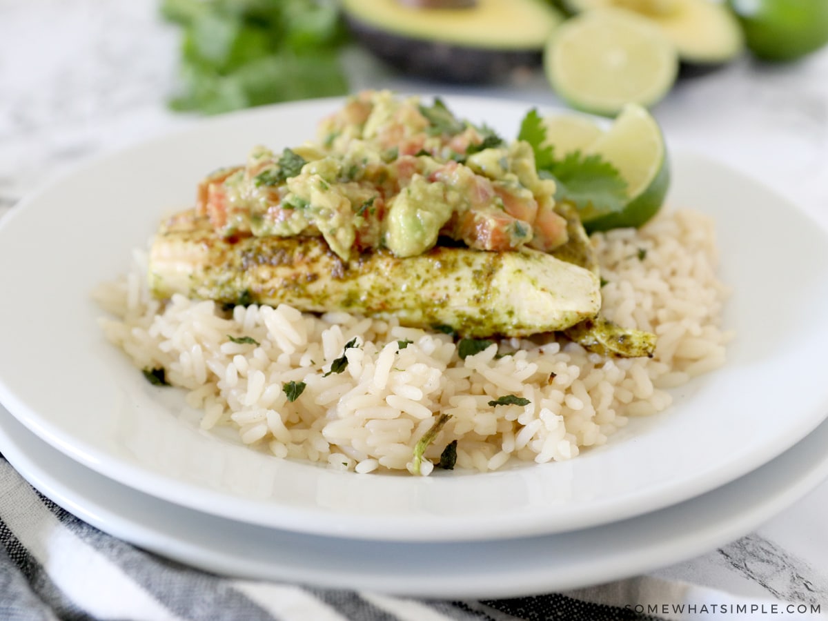 cilantro lime chicken on a bed of rice with avocado salsa on top