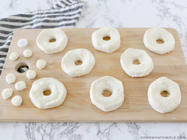 flattening donut dough on a cutting board