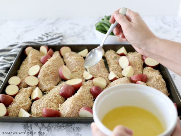 placing vegetables around raw chicken and drizzling with a lemon butter sauce