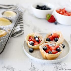 mini dutch baby pancakes topped with berries and sugar