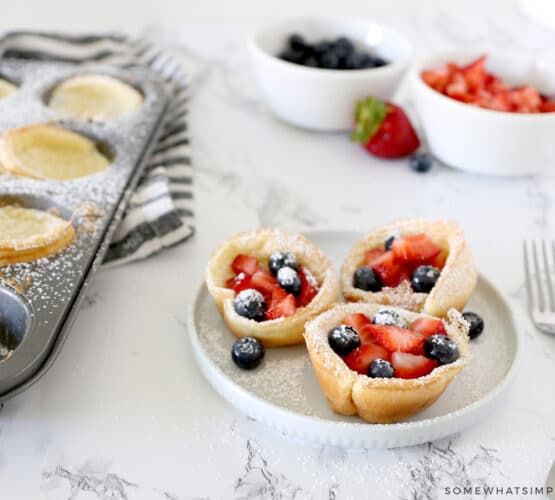 mini dutch baby pancakes topped with berries and sugar