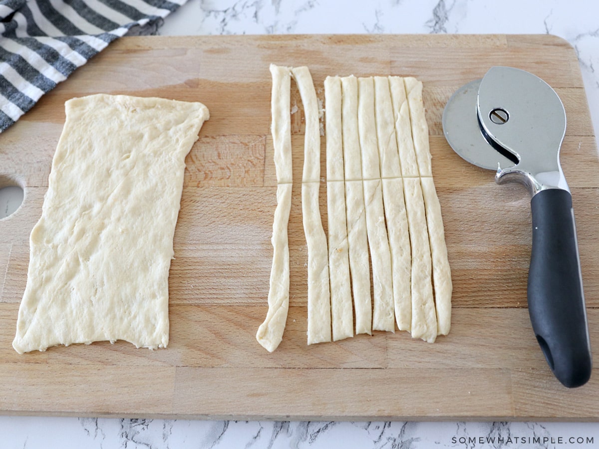 cutting crescent dough with a pizza cutter