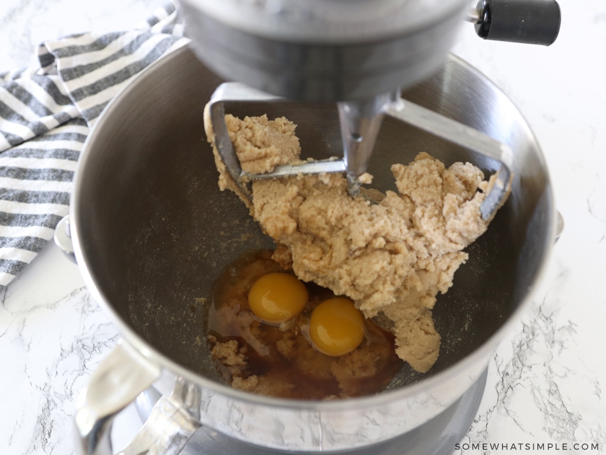 adding eggs and vanilla to cookie dough