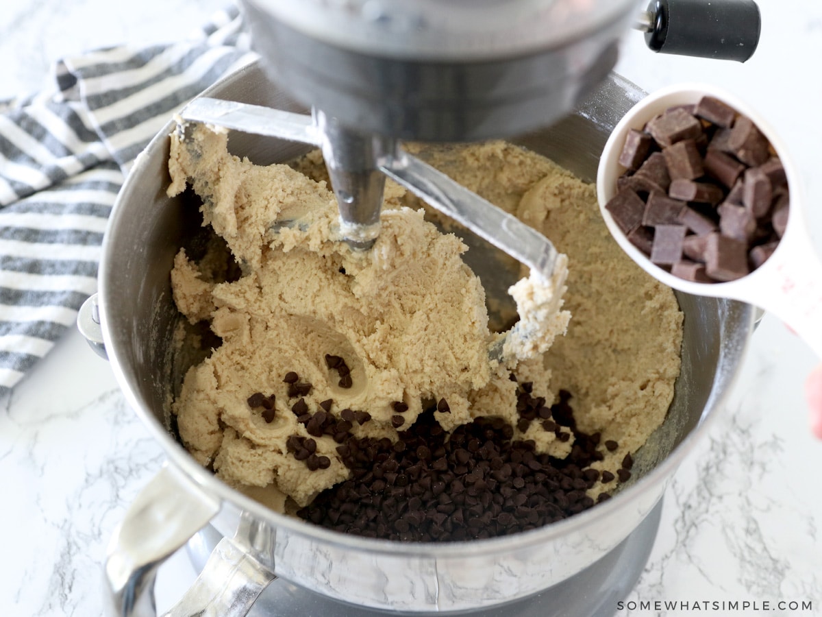 adding chocolate chips to cookie dough
